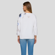 Load image into Gallery viewer, Woman wearing a white sweatshirt with colorful designs on the back, standing against a plain background.