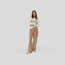 Load image into Gallery viewer, Woman wearing a beige sweater and brown pants on a white background