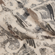 Load image into Gallery viewer, Close-up of a textured fabric with black abstract patterns on a beige background