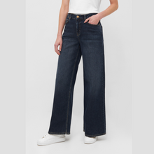 Load image into Gallery viewer, Person wearing dark blue jeans on a white background