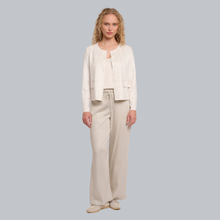 Load image into Gallery viewer, Woman wearing a beige outfit with a jacket and pants on a gray background