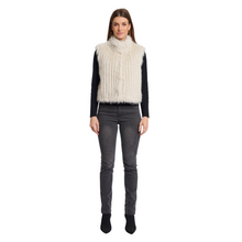 Load image into Gallery viewer, Woman wearing a white fur vest over a black long-sleeve shirt and gray jeans on a white background