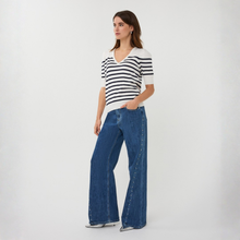 Load image into Gallery viewer, Woman wearing a striped shirt and blue jeans on a white background