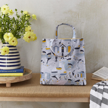 Load image into Gallery viewer, Tote bag with animal pattern on a wooden surface next to a vase with flowers and books.
