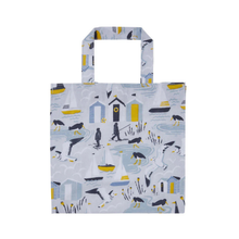 Load image into Gallery viewer, Tote bag with coastal design featuring houses, boats, and birds on a light blue background