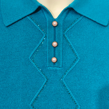 Load image into Gallery viewer, Close-up of a teal knit polo shirt on a mannequin, showing the collar, button placket, and decorative zigzag knit pattern with three pearl-like buttons.