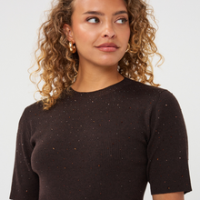 Load image into Gallery viewer, A close-up of a woman with curly blonde hair wearing a dark brown ribbed short-sleeve knit top with subtle gold speckles, paired with gold hoop earrings, against a light gray background.