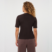 Load image into Gallery viewer, A woman with curly blonde hair is shown from the back wearing a dark brown short-sleeve knit top and brown pants against a plain white studio background.