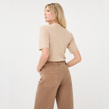Load image into Gallery viewer, A woman shown from the back wearing a beige short-sleeve knit top and brown wide-leg pants against a clean white studio background.