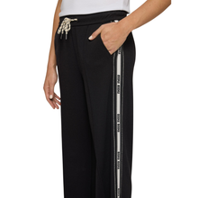 Load image into Gallery viewer, Black pants with a white stripe and brand logo on a white background