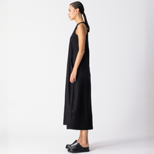 Load image into Gallery viewer, Woman wearing a black sleeveless dress on a white background