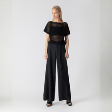 Load image into Gallery viewer, Woman wearing a black outfit with wide-leg pants on a white background