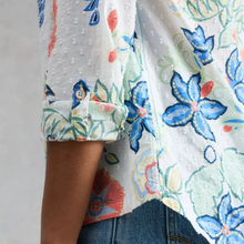 Load image into Gallery viewer, Close-up of a person wearing a colorful floral shirt with rolled-up sleeves.