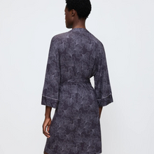 Load image into Gallery viewer, Person wearing a dark floral patterned robe on a light gray background