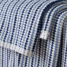 Load image into Gallery viewer, Close-up of blue and white patterned fabric with a tag.