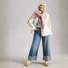 Load image into Gallery viewer, Woman wearing a white coat, pink scarf, blue jeans, and beige shoes against a gray background