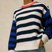 Load image into Gallery viewer, A close-up of a person wearing a knit sweater with horizontal navy and white stripes across the body, bright royal blue sleeves, and a coral-pink ribbed crew neck.