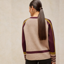 Load image into Gallery viewer, A woman viewed from the back wearing a knit sweater with a large beige center panel and deep burgundy sleeves and horizontal stripe accents, with olive-gold shoulder stripes.