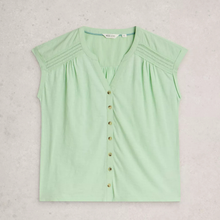 Load image into Gallery viewer, A light mint green sleeveless blouse with a V-neckline, decorative button-down front, and subtle shoulder pleats, laid flat on a textured light gray background.