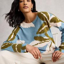 Load image into Gallery viewer, Woman wearing a patterned sweater sitting on a chair with a neutral background