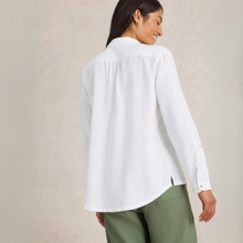 Load image into Gallery viewer, Woman wearing a white shirt and green pants against a beige background