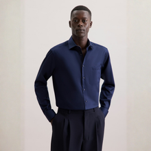Load image into Gallery viewer, Man wearing a navy blue shirt and dark pants against a plain background
