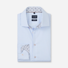 Load image into Gallery viewer, A light blue pinstriped dress shirt by OLYMP, folded neatly to show its patterned inner collar and pocket flap lining, set against a clean off-white background.
