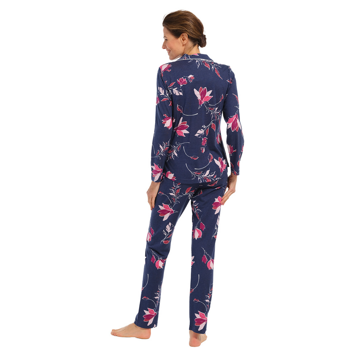 Pyjamas on a female model, button down front with navy palette and fuchsia flowers, model facing back