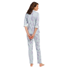 Load image into Gallery viewer, Model standing full length in a pyjama set with a button up top and an overall print with stripes and paisley print - model facing away from the camera
