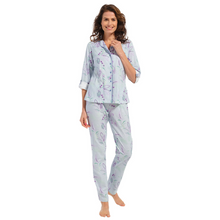 Load image into Gallery viewer, Model standing full length in a pyjama set with a button up top and an overall print with stripes and paisley print
