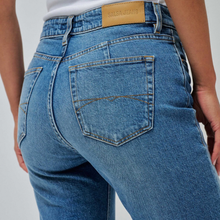 Load image into Gallery viewer, Close-up back view of a person wearing blue denim jeans with a tan leather waistband patch reading Salsa Jeans.
