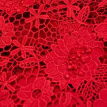 Load image into Gallery viewer, Close-up of red lace fabric with floral patterns
