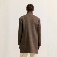 Load image into Gallery viewer, A man viewed from behind wearing a mid-length brown wool-blend coat with a high stand collar and light-colored trousers, set against a plain off-white background.
