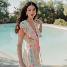 Load image into Gallery viewer, Woman in a colorful dress standing by a pool with trees in the background
