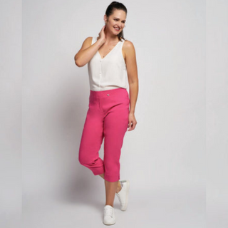 female model wearing pinns cropped trousers in fuschia colour looking away from camera smiling