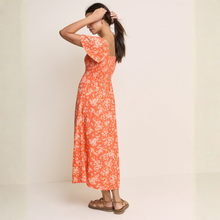 Load image into Gallery viewer, Woman wearing an orange floral dress against a plain background
