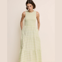 Load image into Gallery viewer, Woman wearing a green checkered dress against a beige background
