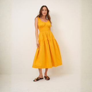 Woman wearing a yellow dress against a white background