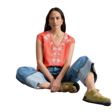 Load image into Gallery viewer, Model on ground wearing White Stuff Floral Top  Fliss with a white background
