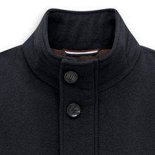 Load image into Gallery viewer, Close-up of a navy wool-like jacket with a high stand collar and two dark buttons, shown against a plain white background.
