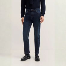 Load image into Gallery viewer, Person wearing dark blue jeans and black shoes on a white background
