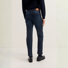 Load image into Gallery viewer, Person wearing dark blue jeans on a light gray background
