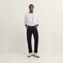 Load image into Gallery viewer, Man wearing a white shirt and dark pants on a plain background
