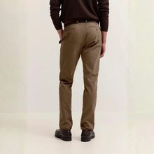 Load image into Gallery viewer, A person shown from the back wearing slim-fit brown trousers, a dark brown sweater, and dark brown shoes against a plain off-white studio background.
