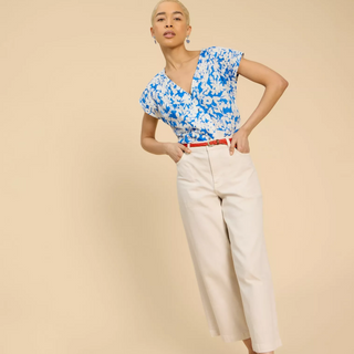 female model wearing whitestuff top in blue colour with hands in pockets