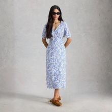 Load image into Gallery viewer, Woman wearing a blue floral dress against a plain background
