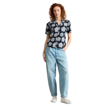 Load image into Gallery viewer, Woman wearing a patterned shirt and light blue jeans on a white background
