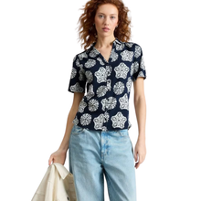 Load image into Gallery viewer, Woman wearing a navy blue floral blouse and light blue jeans on a white background
