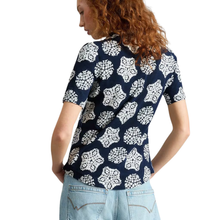 Load image into Gallery viewer, Woman wearing a navy blue top with white floral pattern and light blue jeans on a white background
