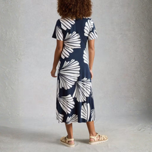 Load image into Gallery viewer, Person wearing a navy dress with white leaf pattern against a gray background
